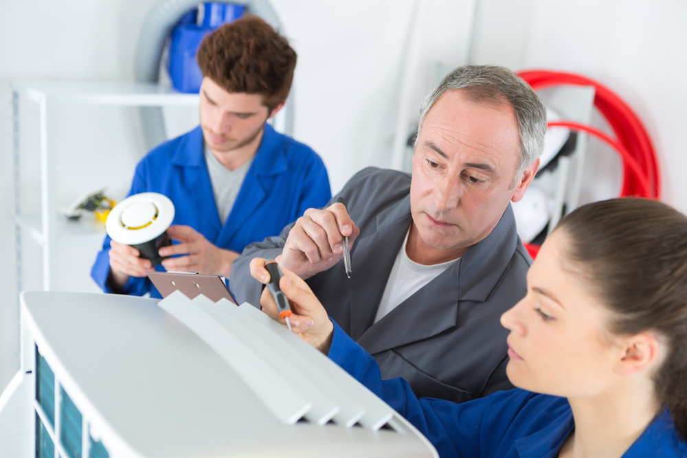 man training his employees in HVAC; invest in your team